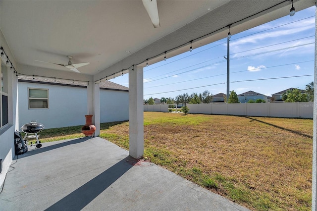 view of yard with ceiling fan and a patio