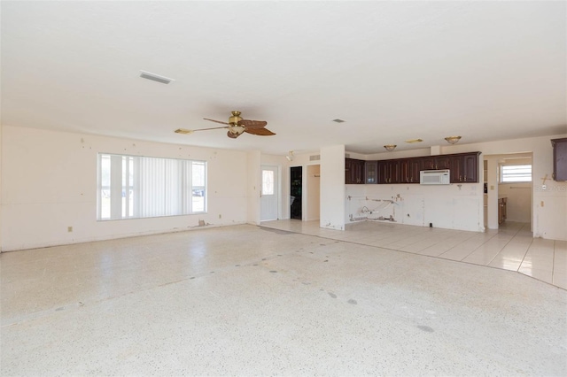 unfurnished living room with ceiling fan and light tile patterned flooring