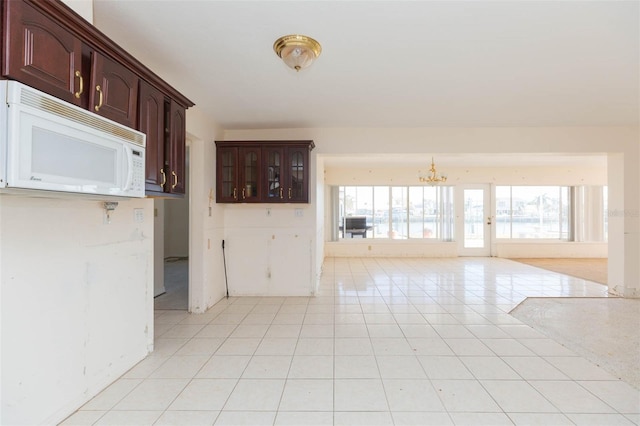 unfurnished room featuring a chandelier and light tile patterned floors