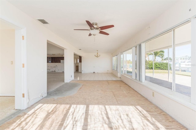 unfurnished sunroom featuring ceiling fan