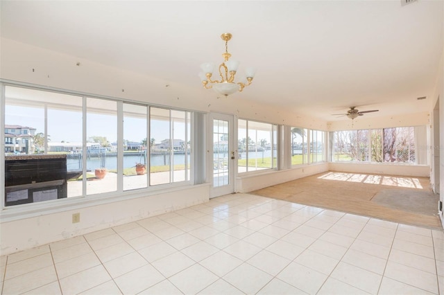 sunroom featuring a water view and ceiling fan with notable chandelier