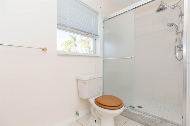 bathroom featuring tile patterned flooring, toilet, and an enclosed shower