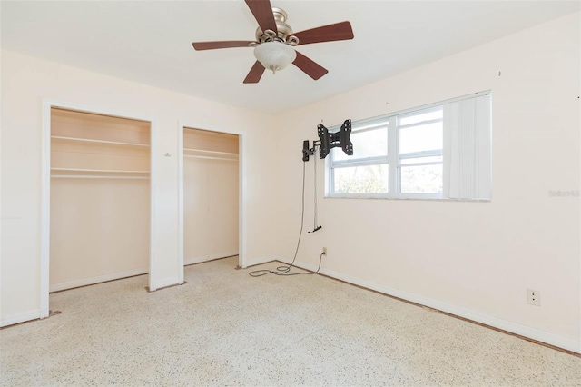 unfurnished bedroom featuring two closets and ceiling fan