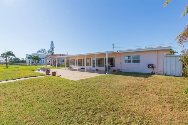 rear view of property with a sunroom and a lawn