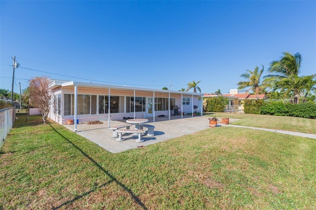 back of house featuring a yard, a patio area, and a sunroom