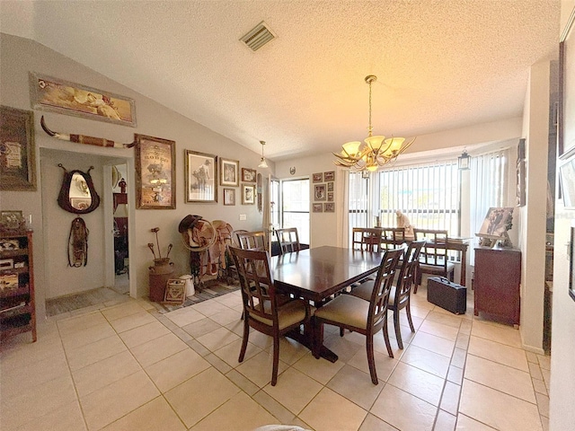 tiled dining space with a textured ceiling, vaulted ceiling, and an inviting chandelier