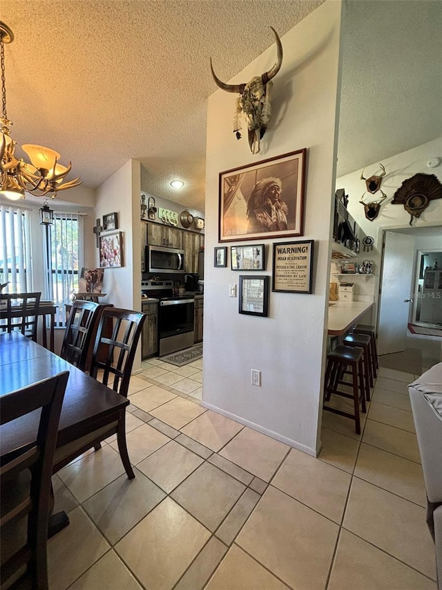 dining space with light tile patterned flooring, a textured ceiling, and a chandelier