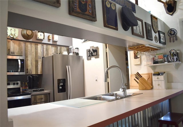 kitchen featuring kitchen peninsula, appliances with stainless steel finishes, and sink