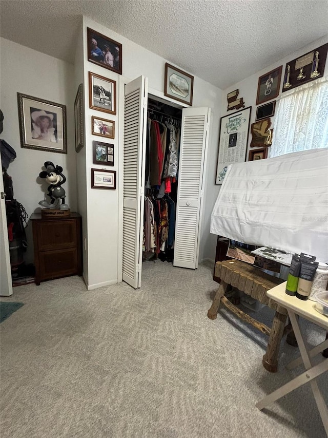 carpeted bedroom with a closet and a textured ceiling