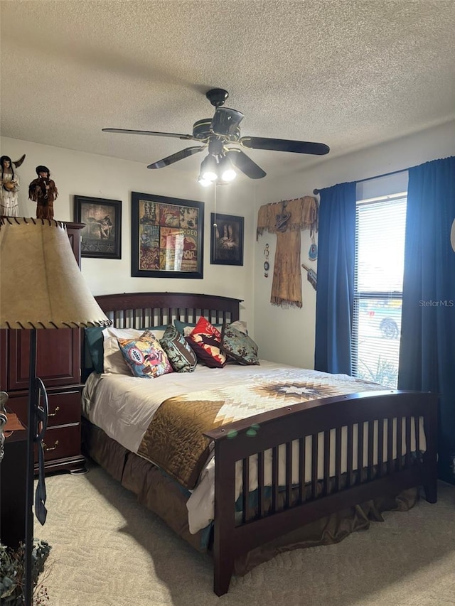 carpeted bedroom with a textured ceiling and ceiling fan