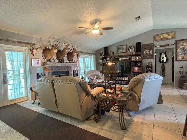 living room featuring light tile patterned floors, plenty of natural light, lofted ceiling, and ceiling fan