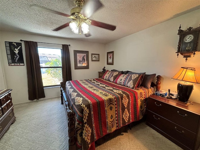 carpeted bedroom featuring ceiling fan and a textured ceiling