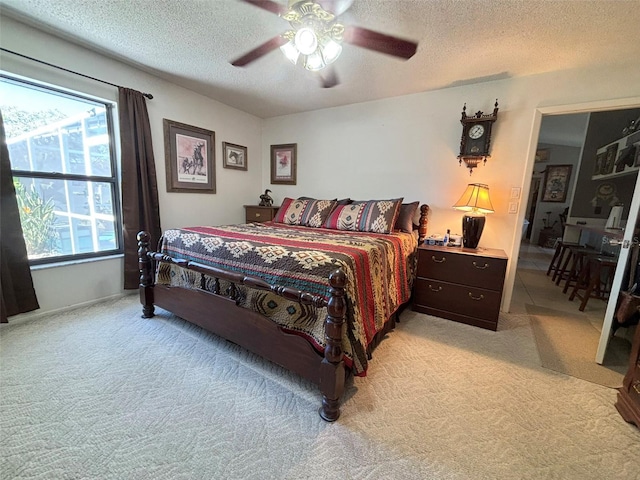 carpeted bedroom featuring ceiling fan and a textured ceiling