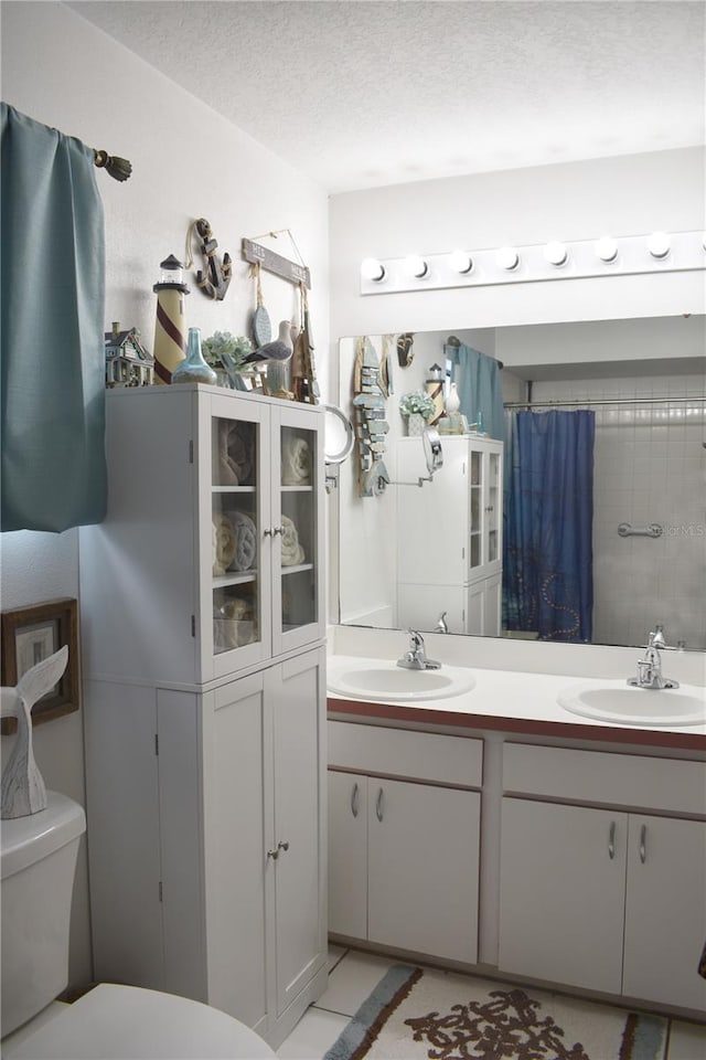 bathroom with vanity, a shower with shower curtain, tile patterned flooring, toilet, and a textured ceiling