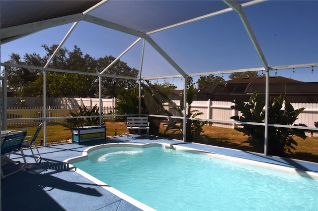 view of swimming pool featuring glass enclosure and a patio