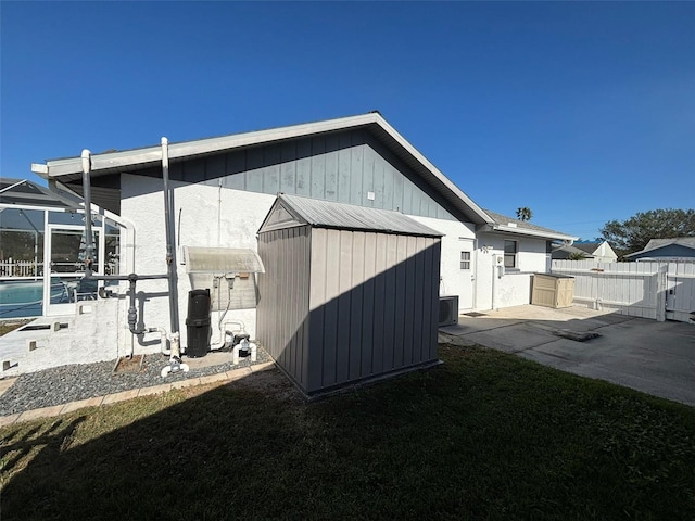 view of home's exterior featuring a fenced in pool, central air condition unit, a patio, and a storage unit