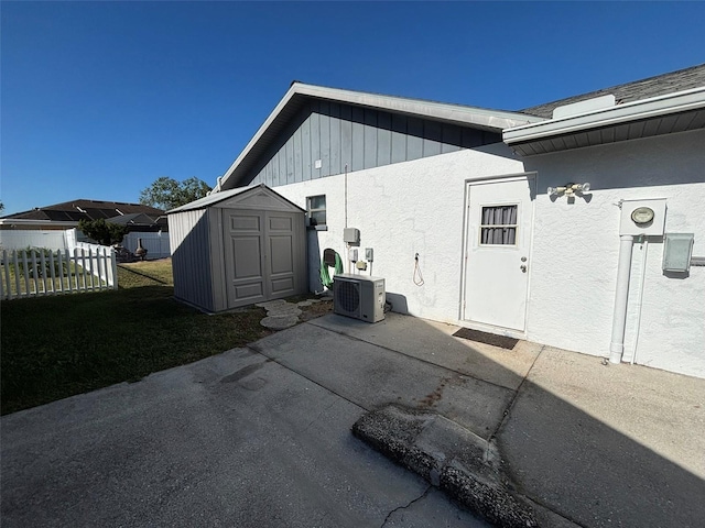 view of side of home with a patio area, a storage shed, and central air condition unit