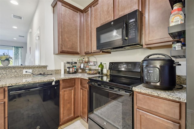 kitchen with light stone countertops and black appliances