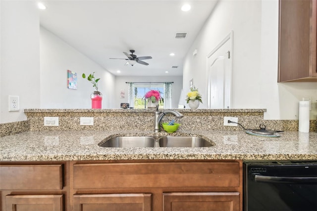 kitchen featuring black dishwasher, light stone counters, ceiling fan, and sink