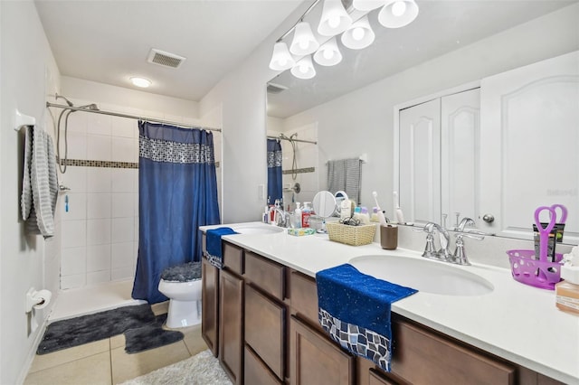 bathroom featuring tile patterned flooring, vanity, toilet, and walk in shower