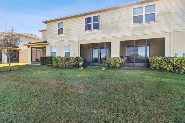 rear view of property featuring a lawn