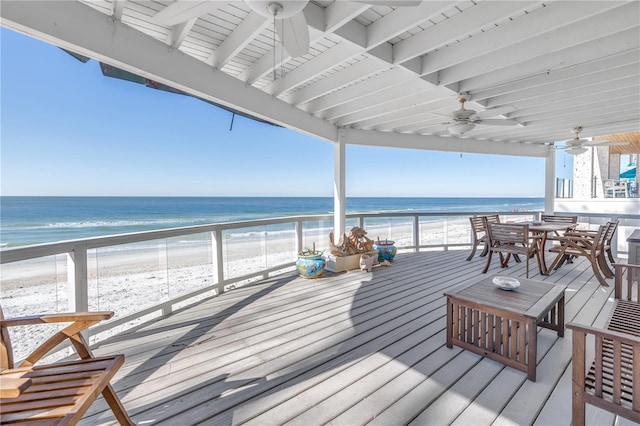 wooden terrace featuring a water view and a view of the beach