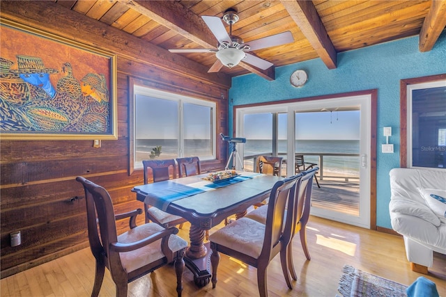 dining room with light wood-type flooring, a water view, ceiling fan, and wood ceiling