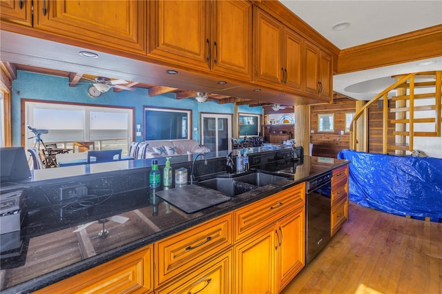 kitchen featuring light wood-type flooring, ceiling fan, sink, dark stone countertops, and black dishwasher