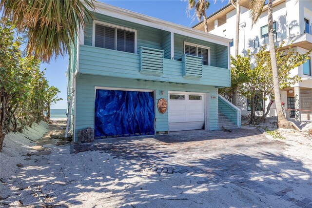 view of front of property featuring a balcony and a garage