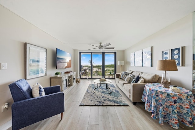 living room featuring light hardwood / wood-style flooring, expansive windows, and ceiling fan