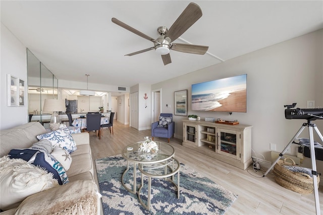 living room featuring ceiling fan and light hardwood / wood-style flooring