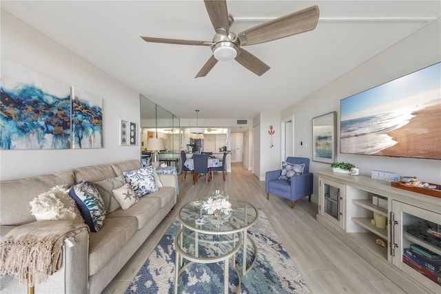 living room featuring light wood-type flooring and ceiling fan