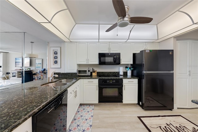 kitchen featuring dark stone counters, sink, white cabinets, and black appliances