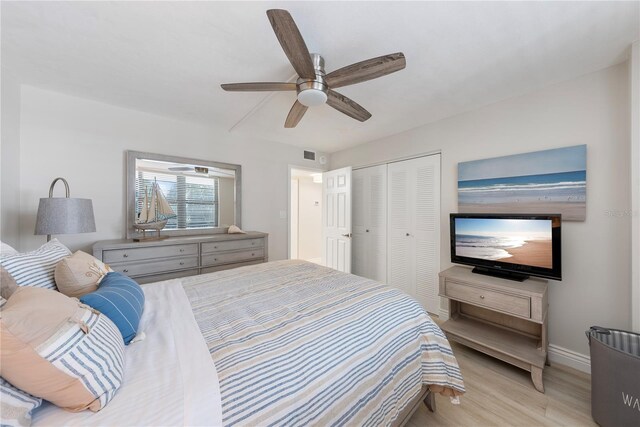 bedroom with ceiling fan, light wood-type flooring, and a closet