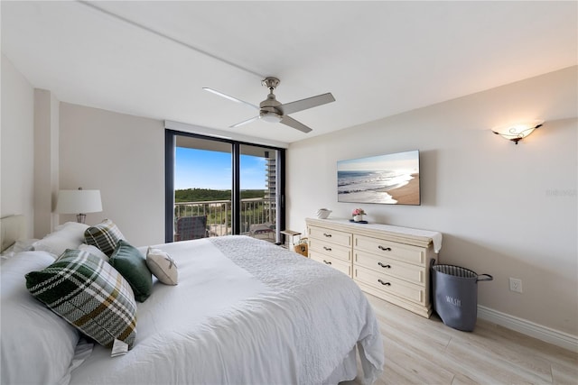 bedroom featuring ceiling fan, light hardwood / wood-style floors, a wall of windows, and access to outside