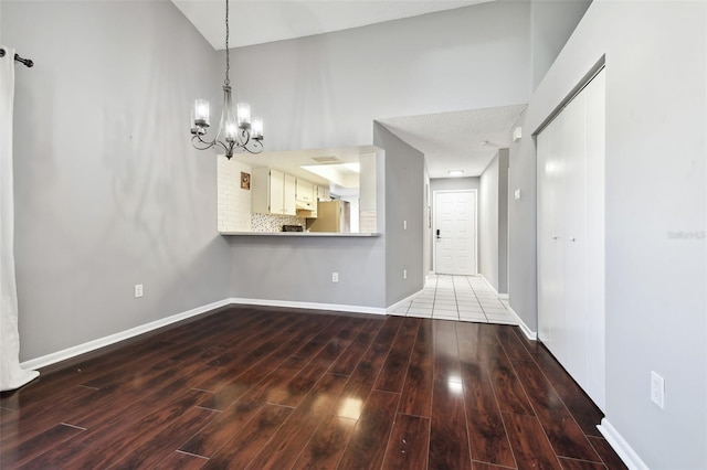 unfurnished living room with hardwood / wood-style flooring and an inviting chandelier