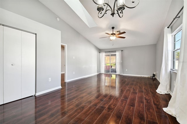 unfurnished bedroom with ceiling fan with notable chandelier, dark hardwood / wood-style floors, vaulted ceiling, and a closet