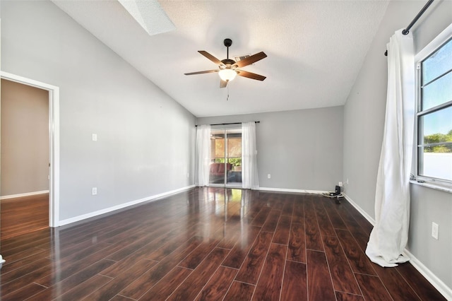 empty room featuring ceiling fan, dark hardwood / wood-style flooring, lofted ceiling, and a textured ceiling