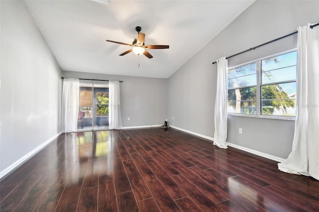 empty room with vaulted ceiling, ceiling fan, and dark hardwood / wood-style floors