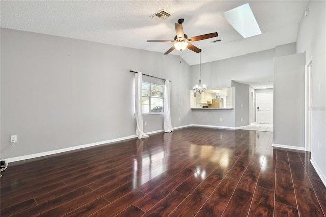 unfurnished living room with ceiling fan with notable chandelier, a textured ceiling, dark hardwood / wood-style flooring, and lofted ceiling with skylight