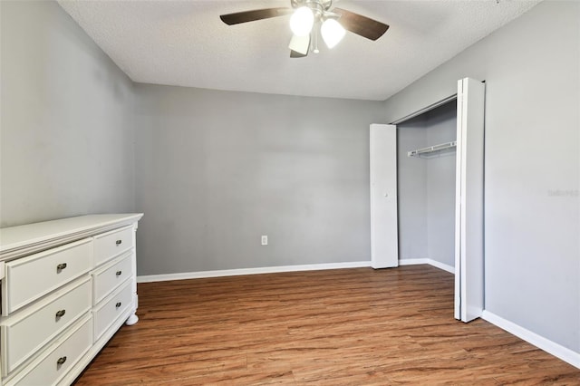 unfurnished bedroom with a closet, ceiling fan, light hardwood / wood-style flooring, and a textured ceiling