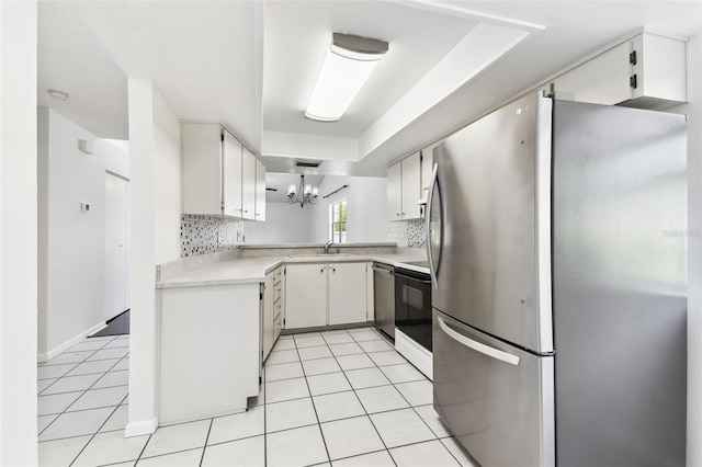 kitchen with decorative backsplash, a chandelier, stainless steel appliances, and light countertops