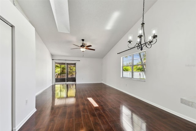 unfurnished living room featuring dark wood-type flooring, lofted ceiling, baseboards, and ceiling fan with notable chandelier