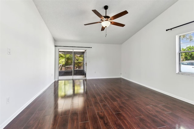 spare room featuring baseboards, a ceiling fan, wood finished floors, and plenty of natural light