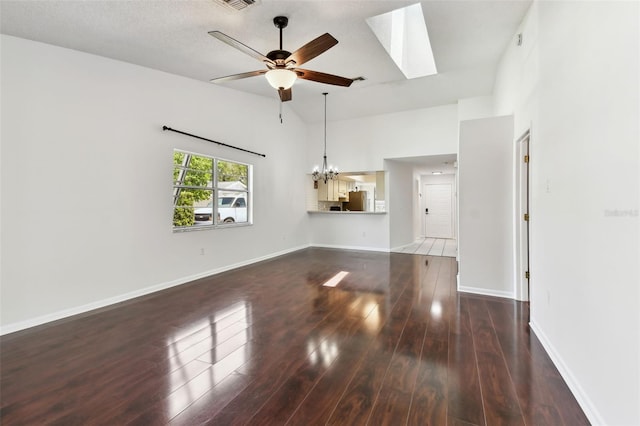 unfurnished living room with wood finished floors, a skylight, ceiling fan with notable chandelier, a high ceiling, and baseboards