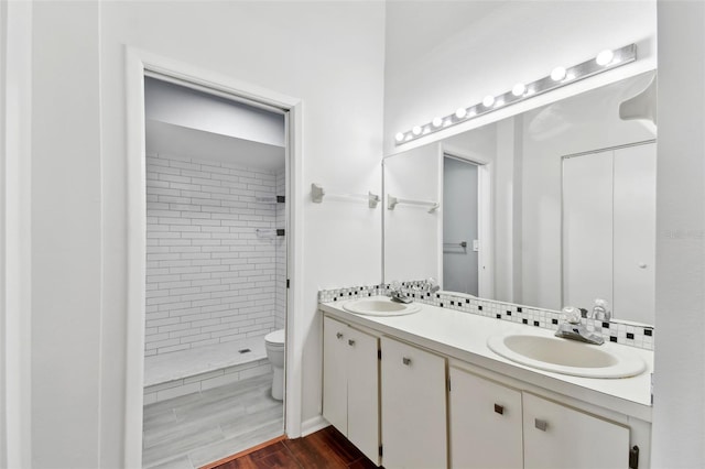 full bath with a shower stall, toilet, a sink, and double vanity