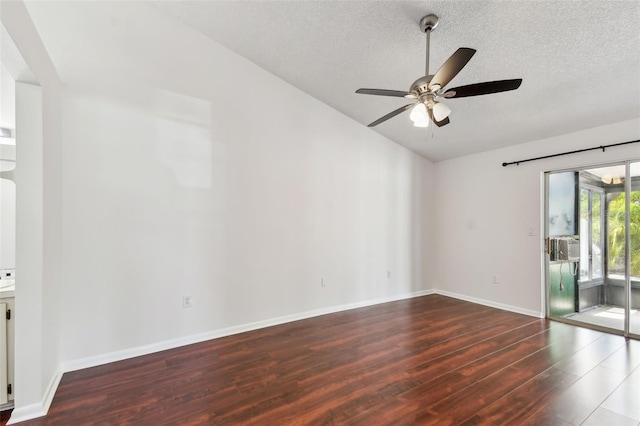 empty room with a textured ceiling, vaulted ceiling, baseboards, wood finished floors, and ceiling fan
