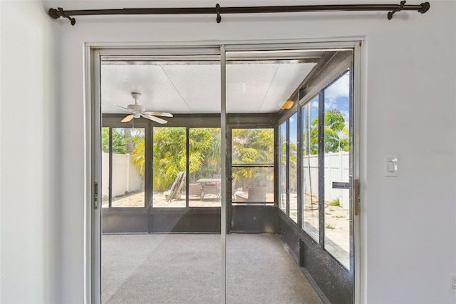 unfurnished sunroom with plenty of natural light and a ceiling fan