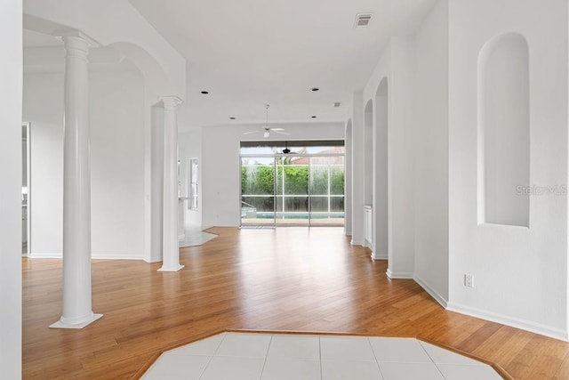 spare room with ceiling fan, light hardwood / wood-style floors, and decorative columns