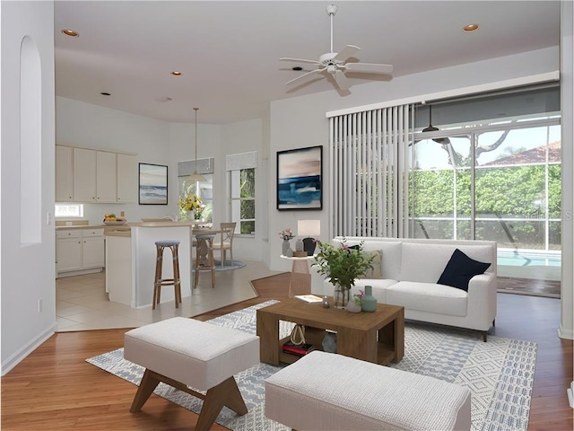 living room with ceiling fan and light hardwood / wood-style flooring